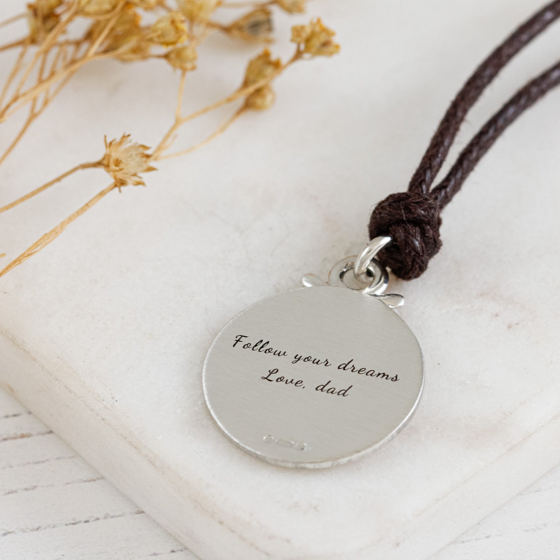 back of matte finish large silver compass st christopher on brown vegan cord