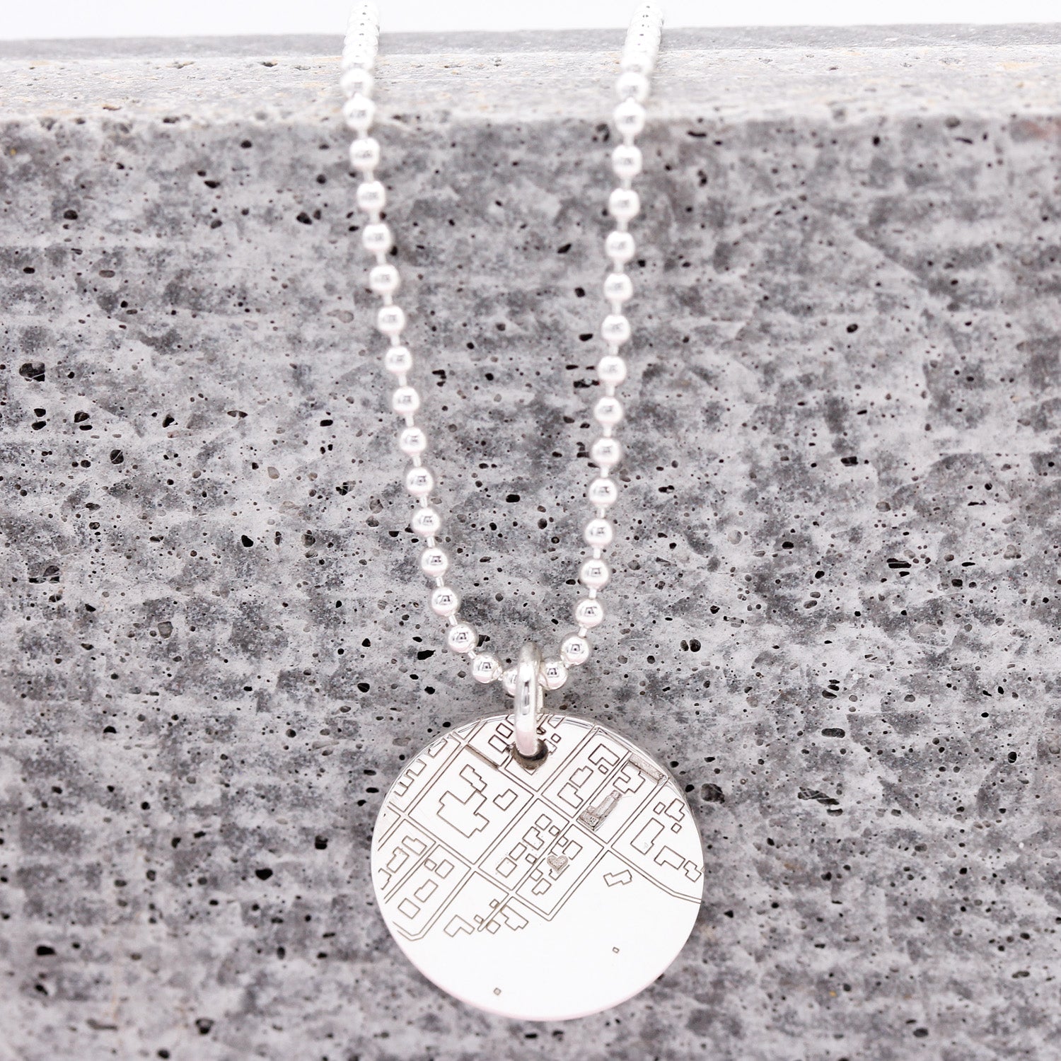 Necklace with a round pendant on a textured surface