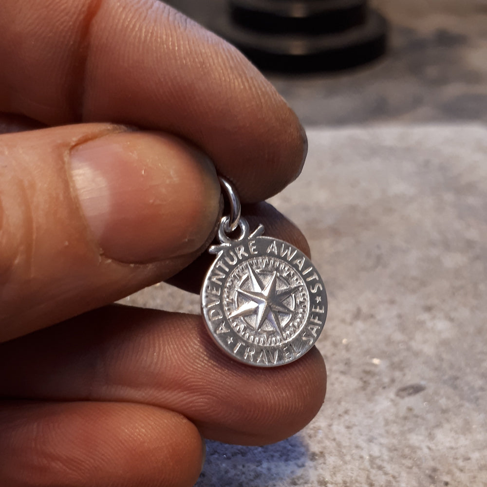 hands making silver compass pendant