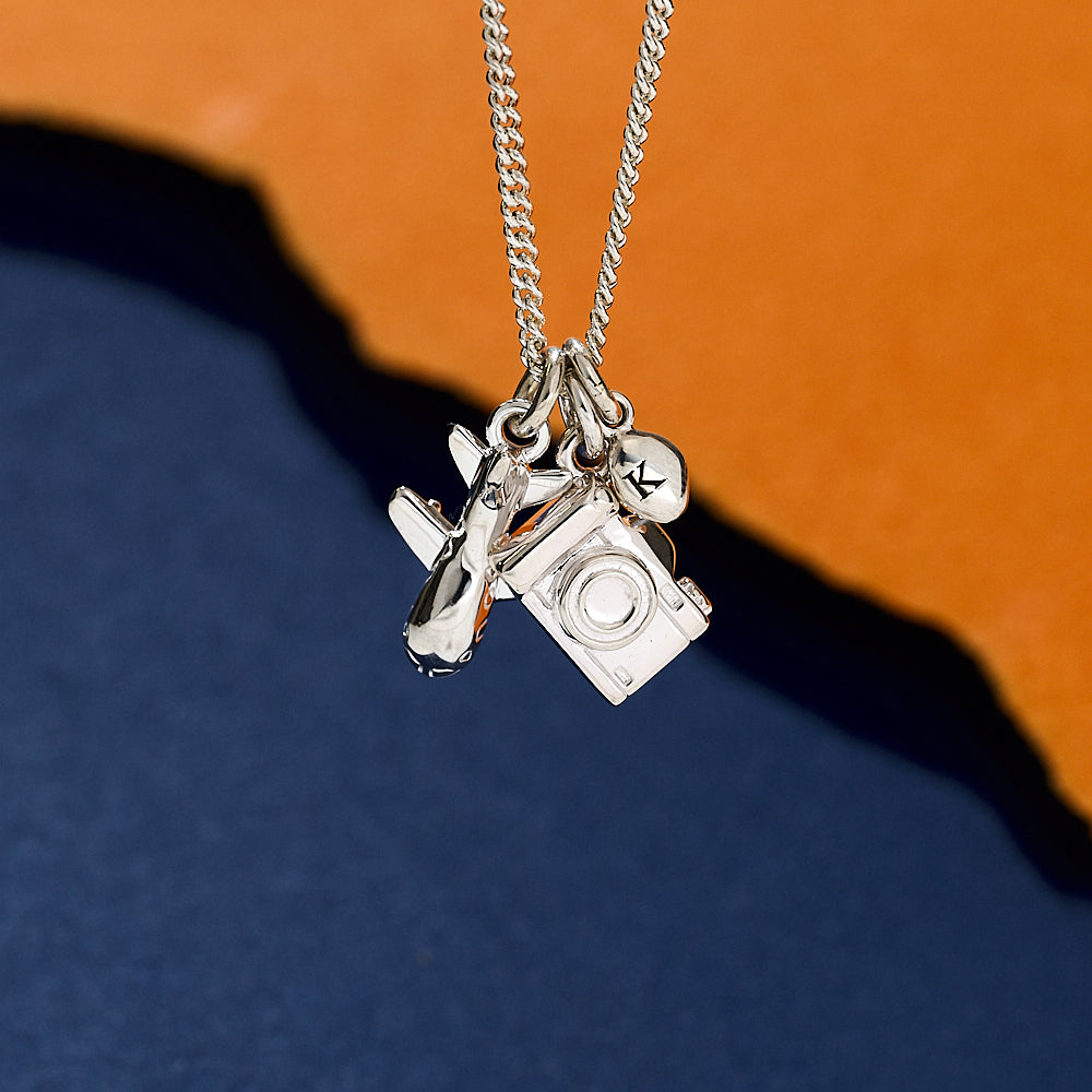Silver necklace with aeroplane camera and pebble charms