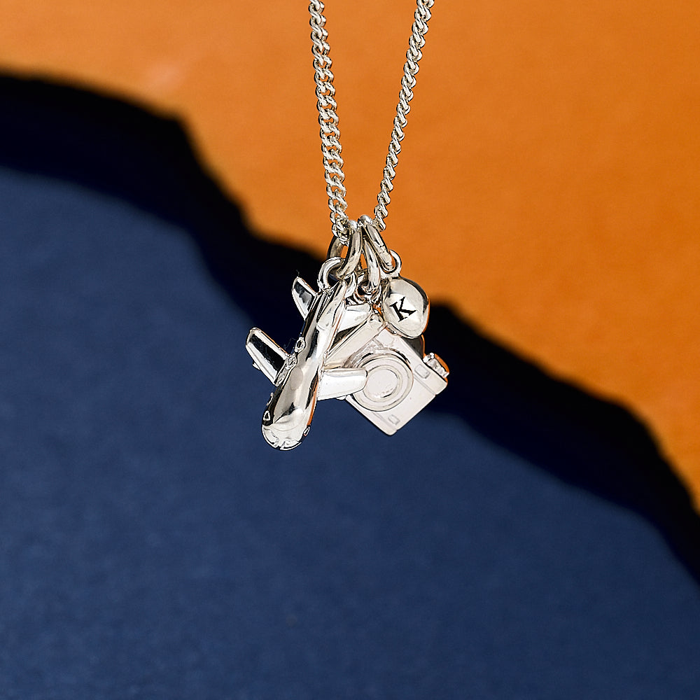 Silver necklace with aeroplane camera and pebble charms