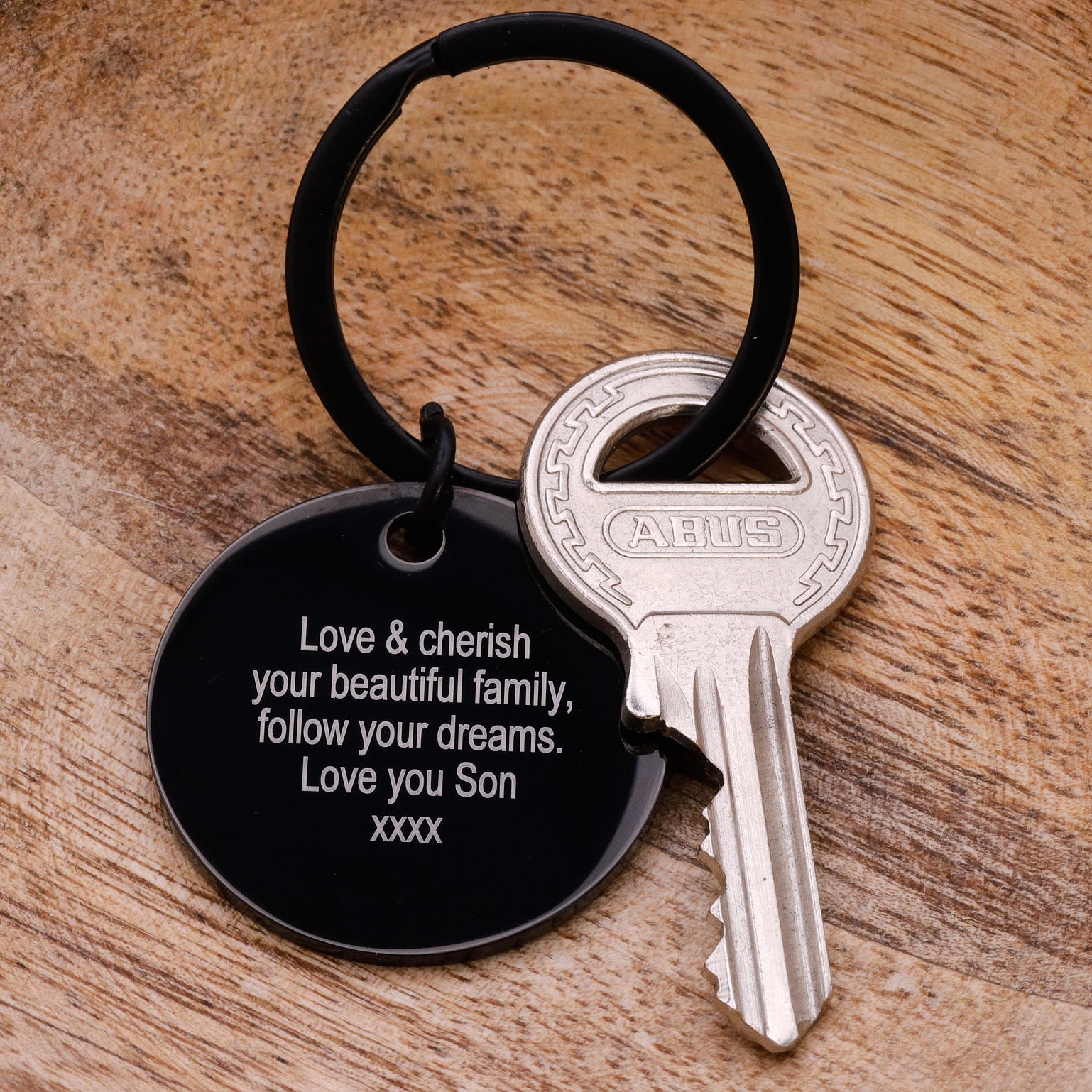 Keychain with a key and motivational message on a wooden surface