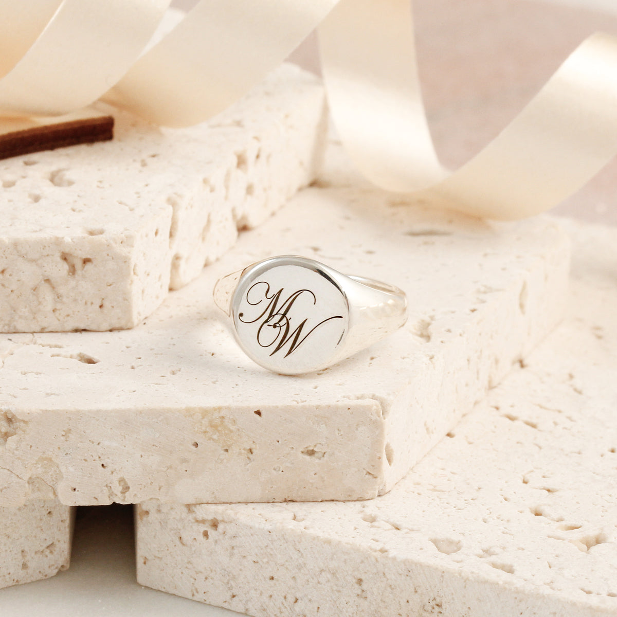 silver signet ring engraved with initials M and W