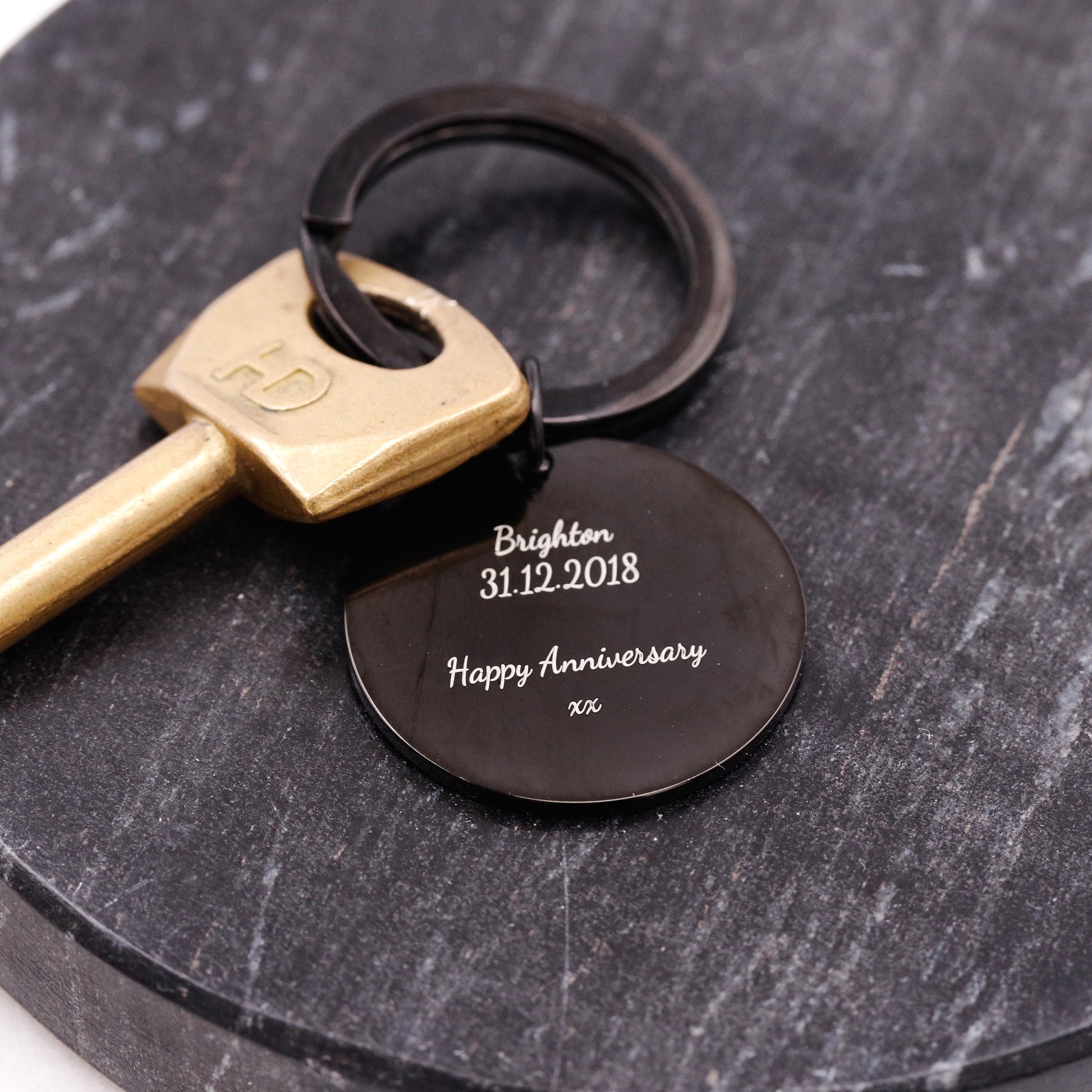 Keychain with engraved message on a dark surface