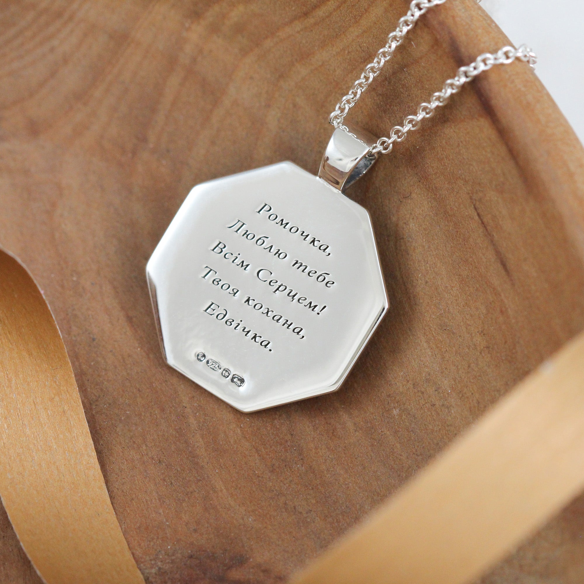 engraved back of octagon rune necklace in greek font