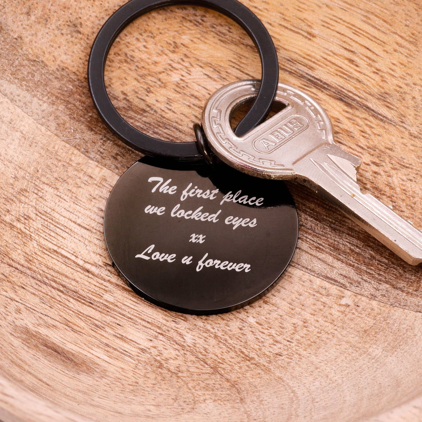 Keychain with engraved message on a wooden surface