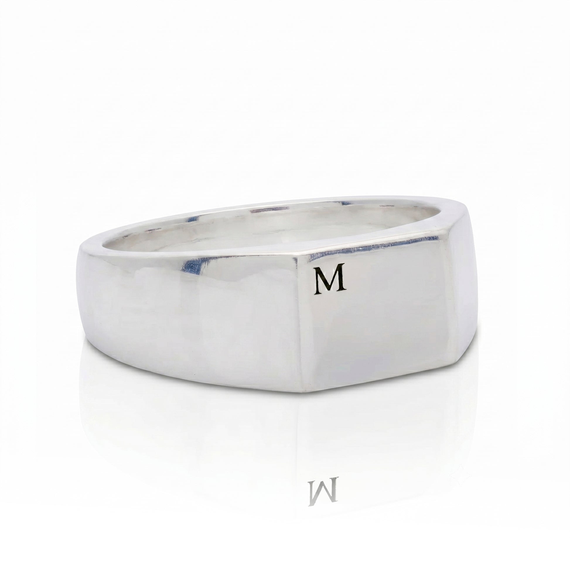 silver signet ring engraved with initial M on white background