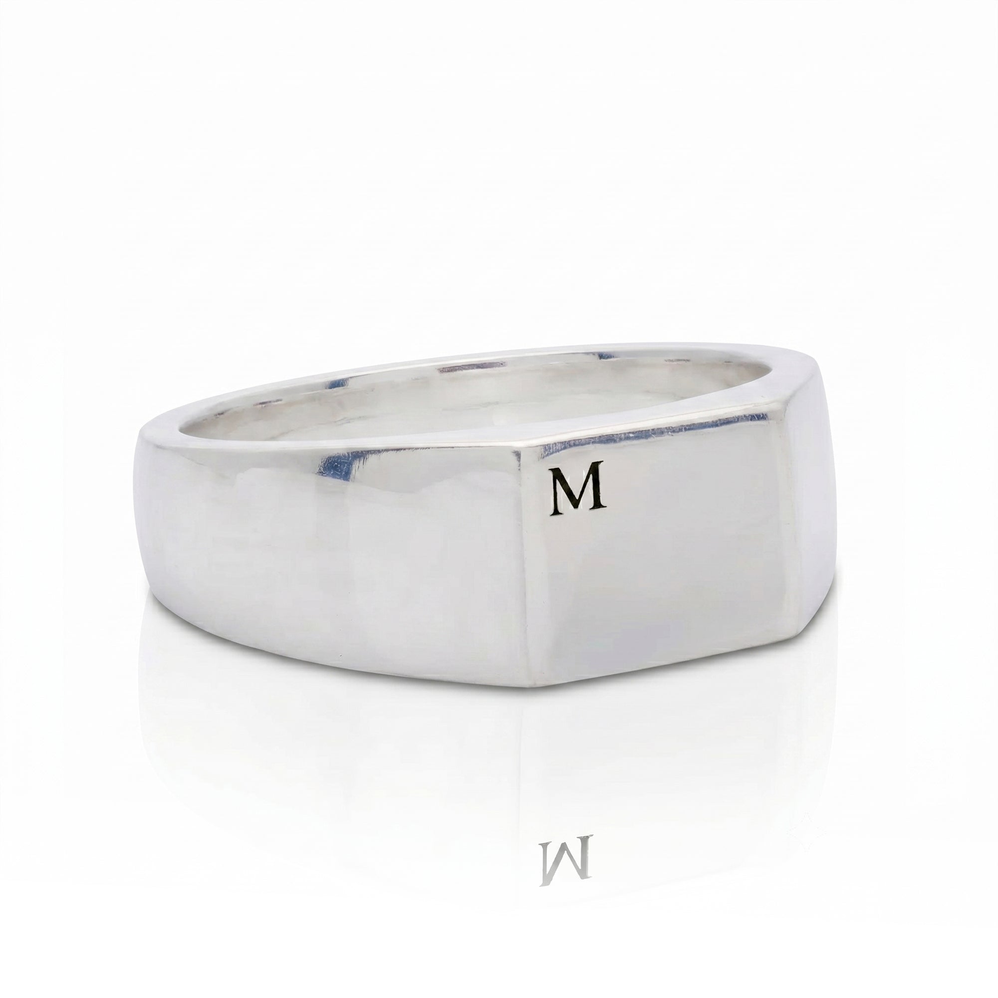 silver signet ring engraved with initial M on white background