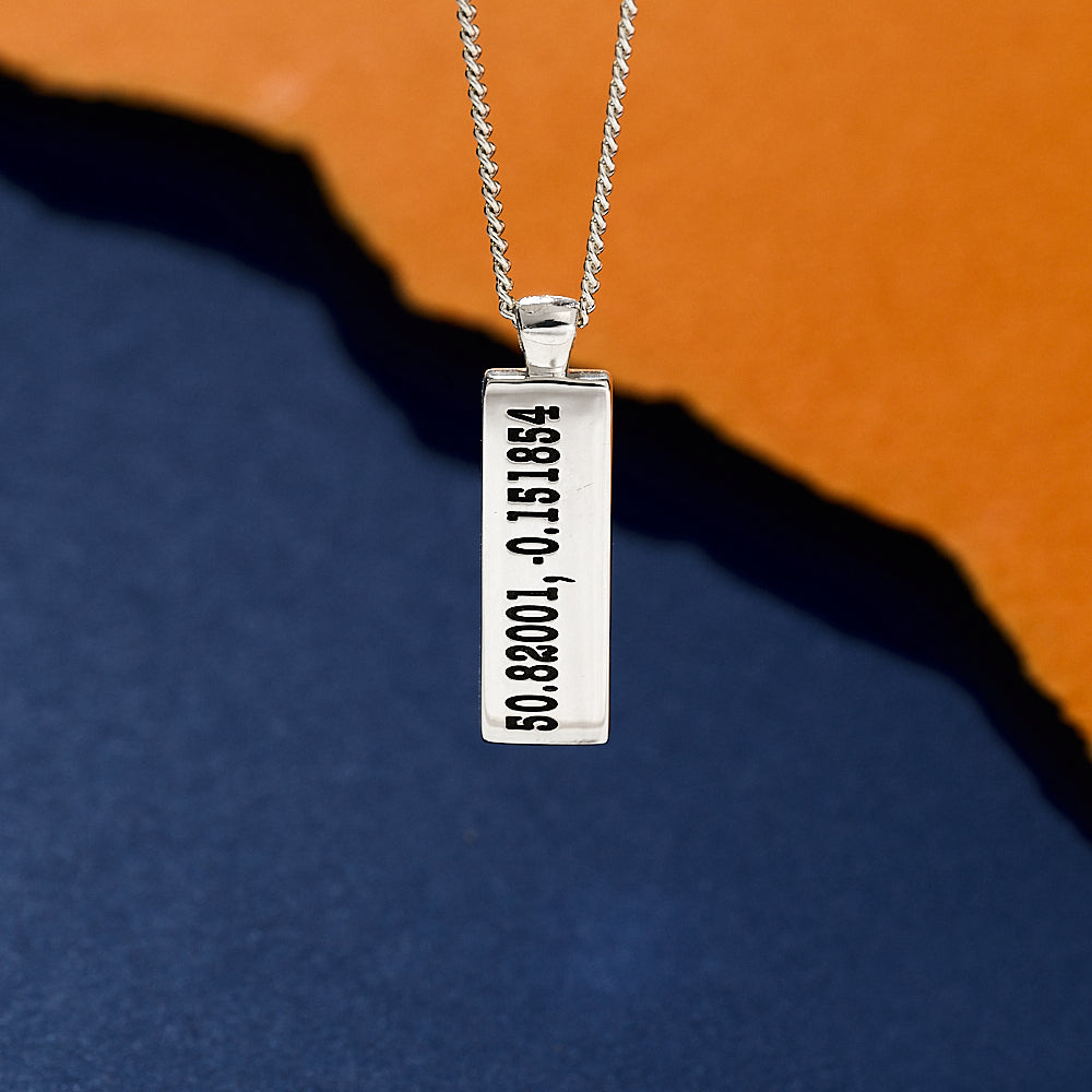 Silver latitude longitude coordinates engraved necklace with a rectangular pendant on a white background