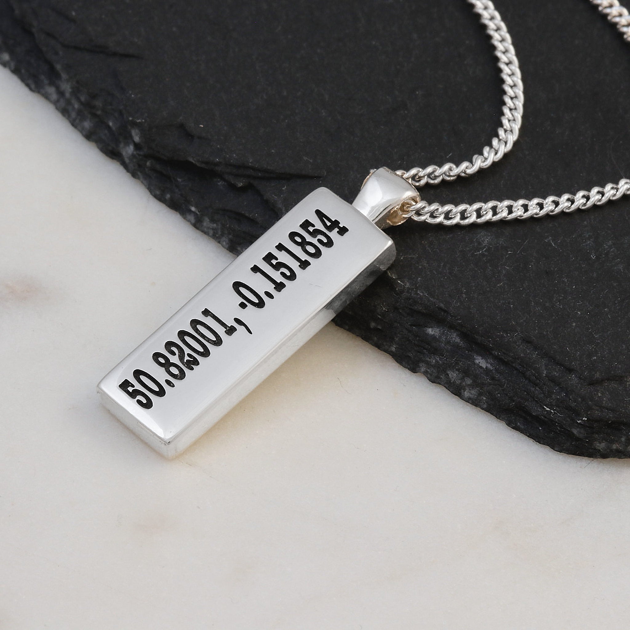 Silver latitude longitude coordinates engraved necklace with a rectangular pendant on a white background