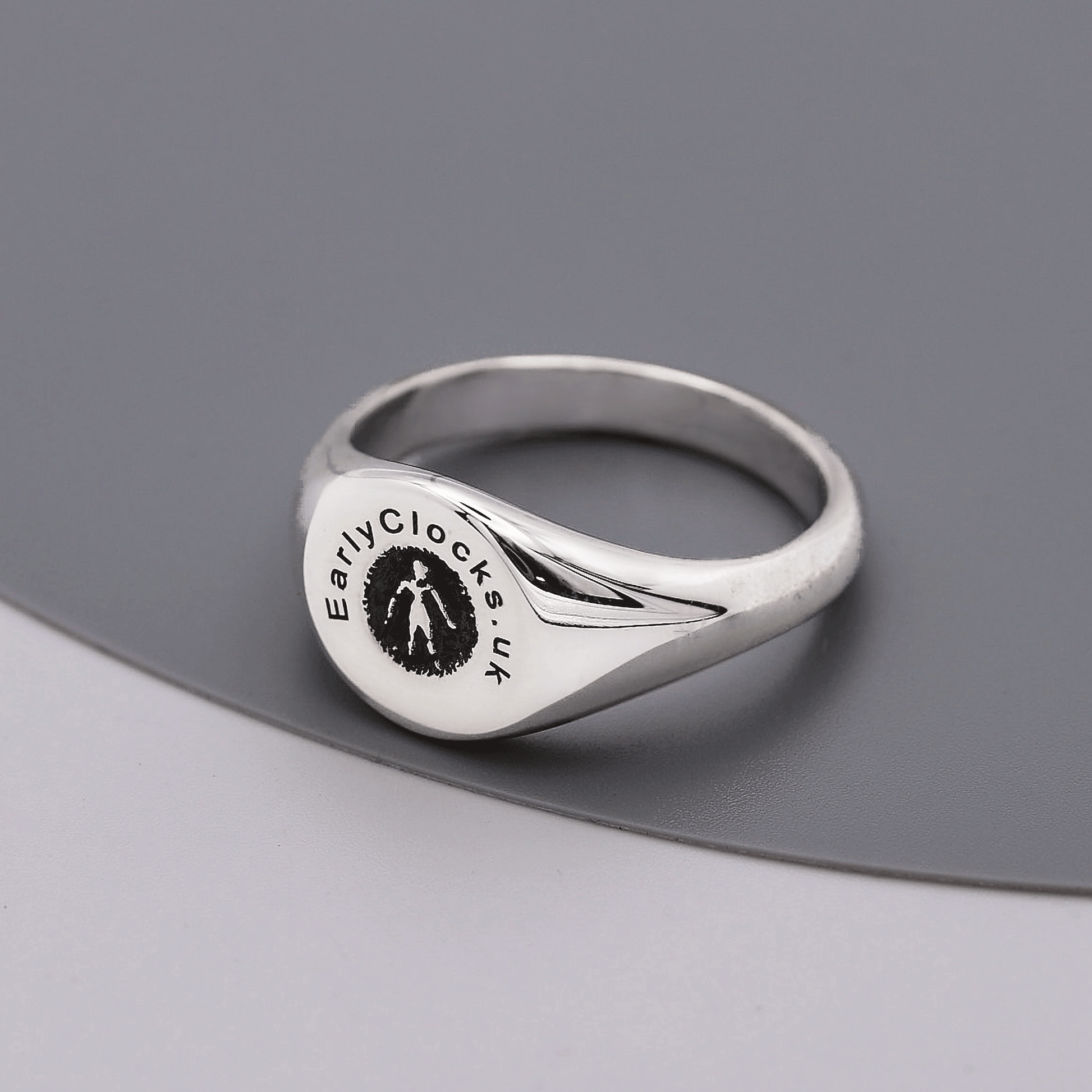 Silver ring with 'EarlyClocks.co.uk' engraving on a gray background