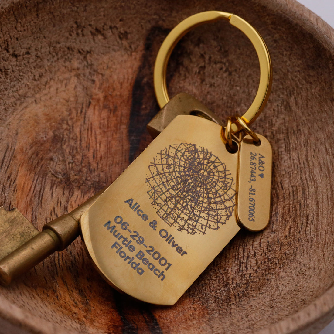 Gold key and keychain with engraved text on a wooden surface