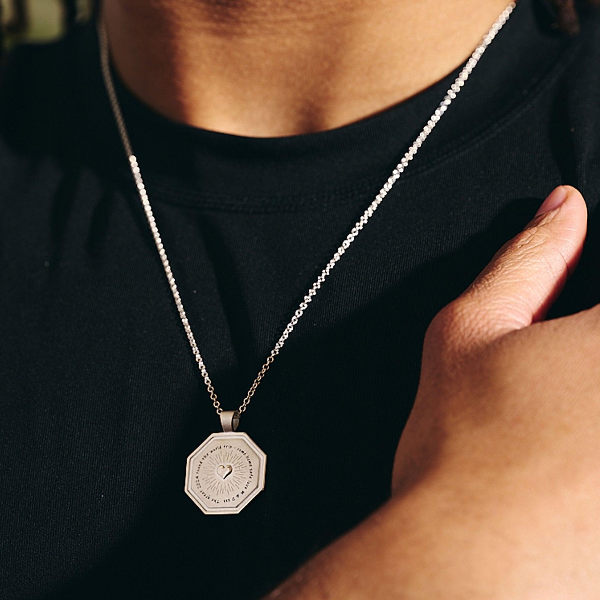 raised heart octagon pendant with sacred heart style detailing and engraved good luck travels message