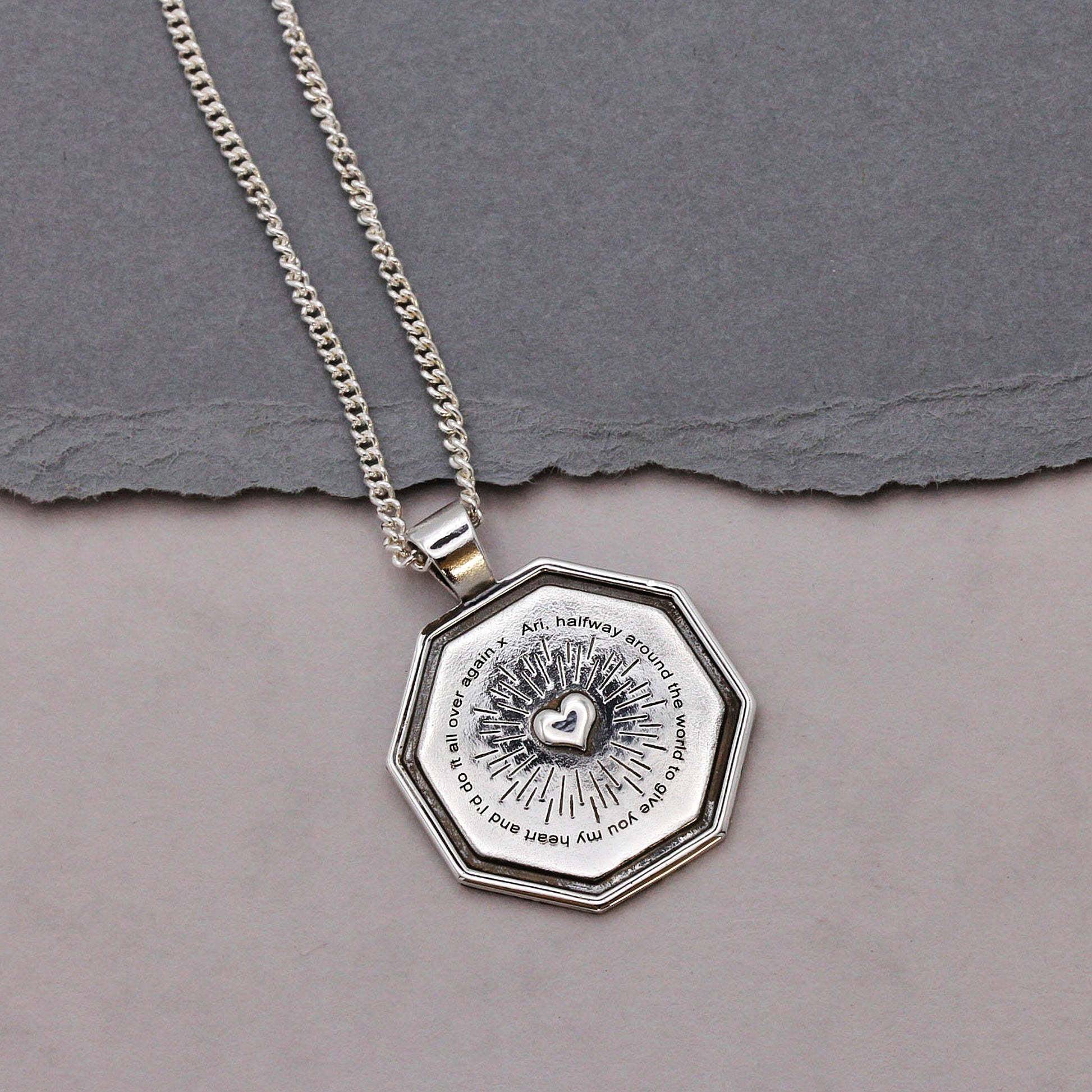 Silver necklace with an octagonal pendant on a gray background