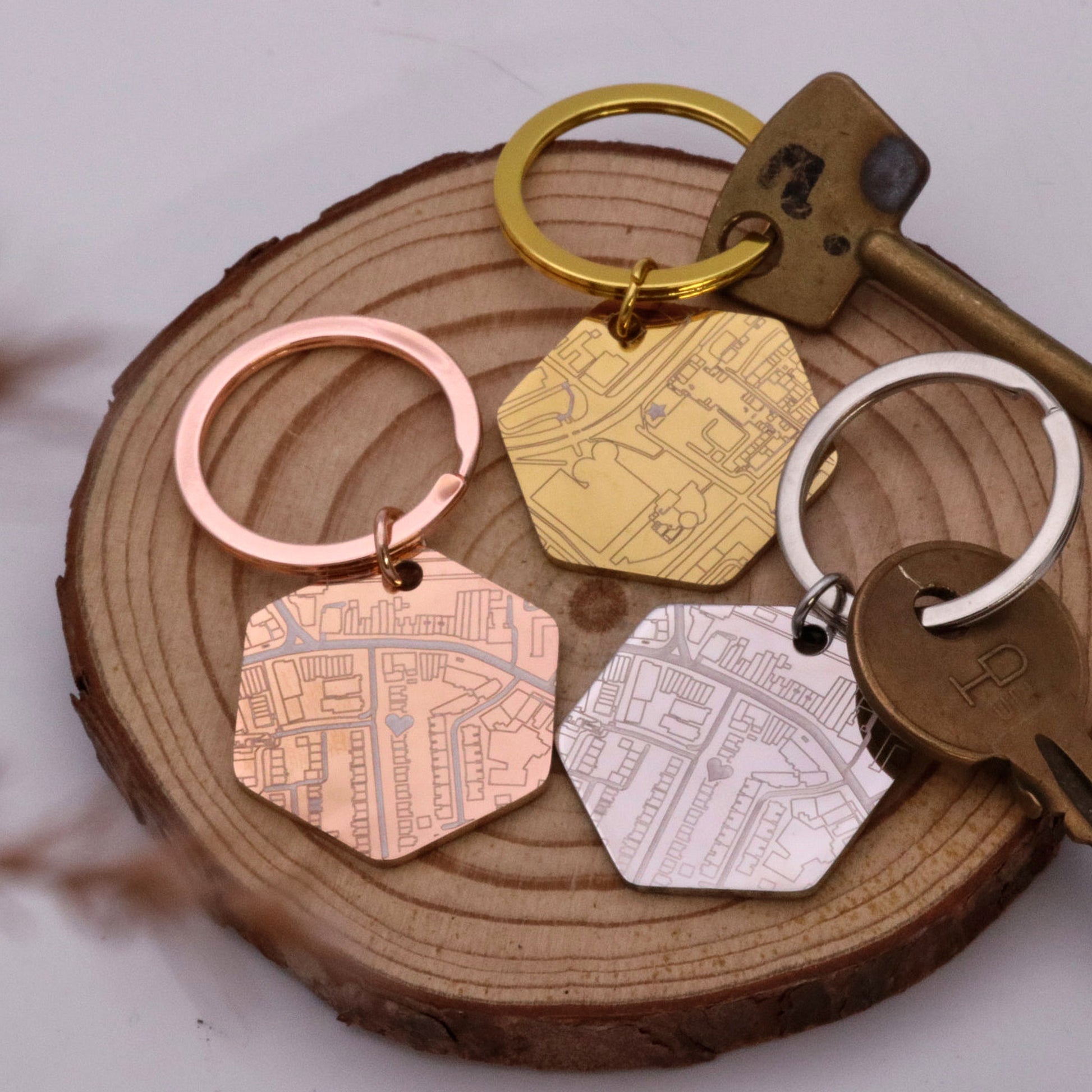 Set of keychains with map designs on a wooden surface
