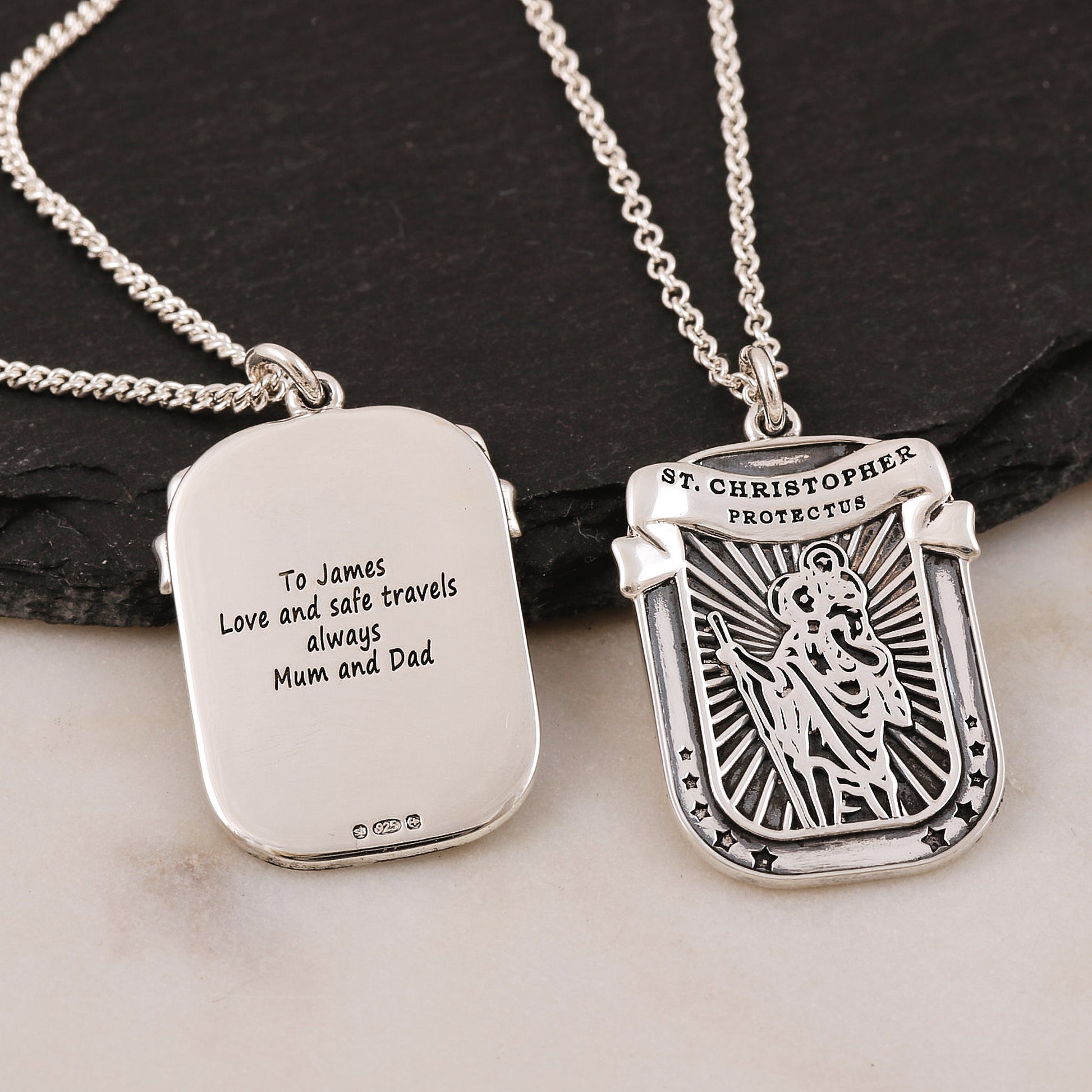 Silver St christopher oxidised pendant with engraved text on a dark surface