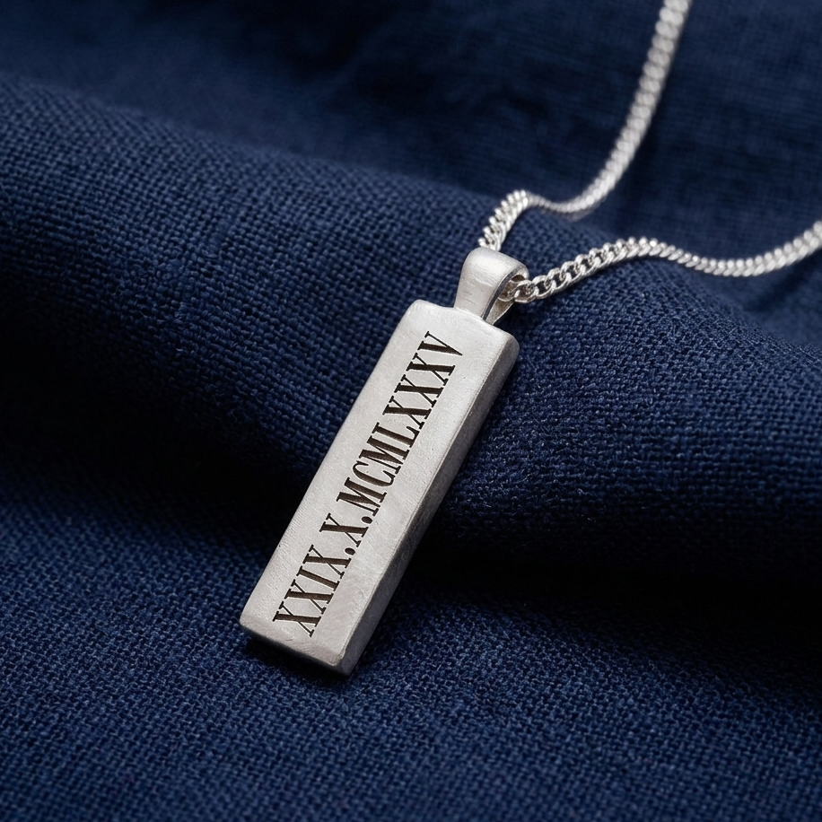 Silver pendant with Roman numerals on a dark blue fabric background