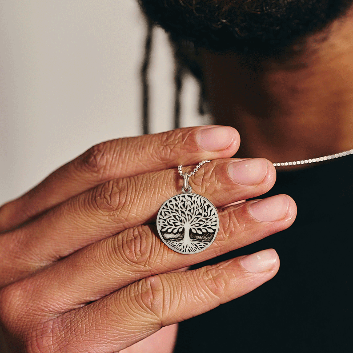 Silver tree-of-life pendant being worn by a  man