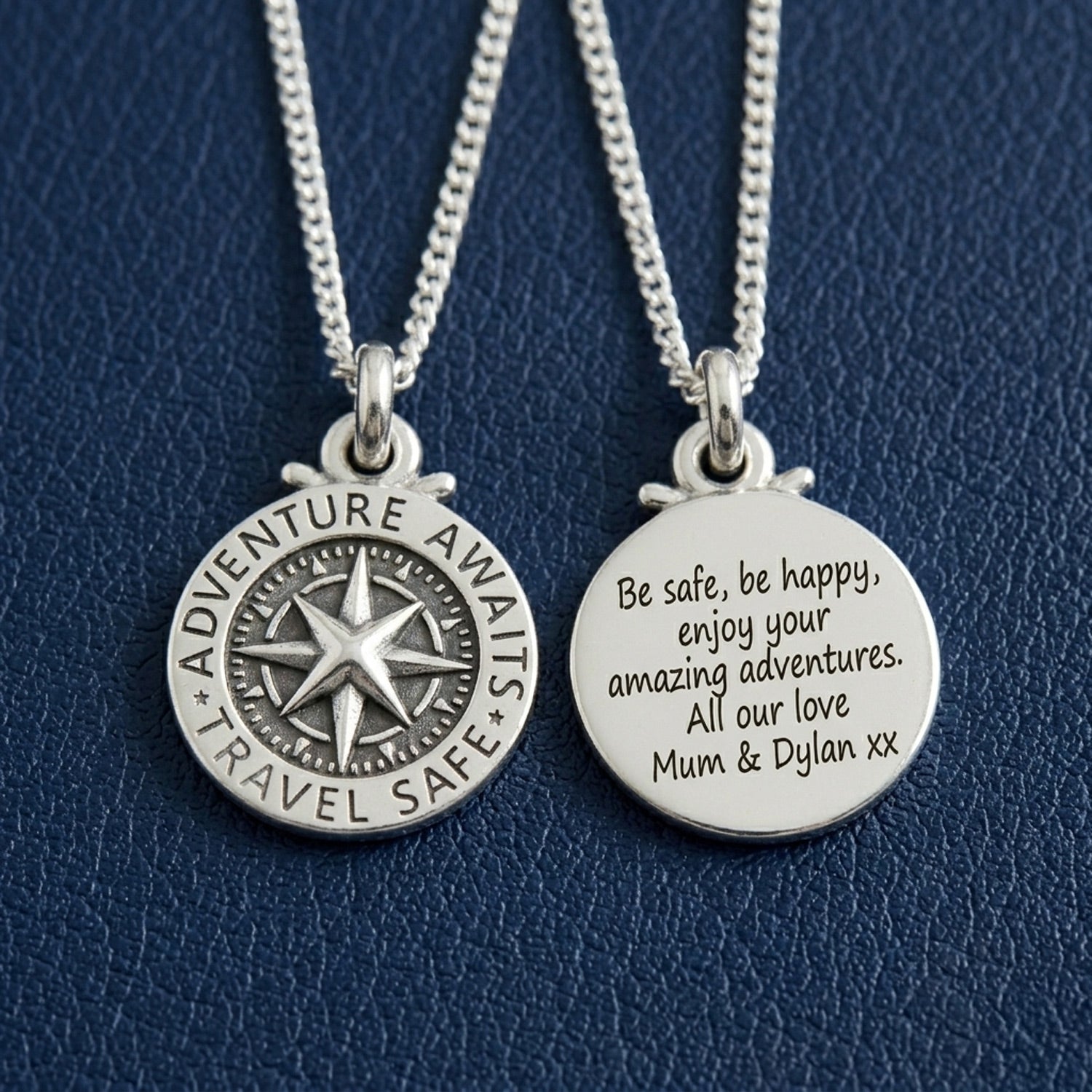 Two silver necklaces with engraved pendants on a blue textured background