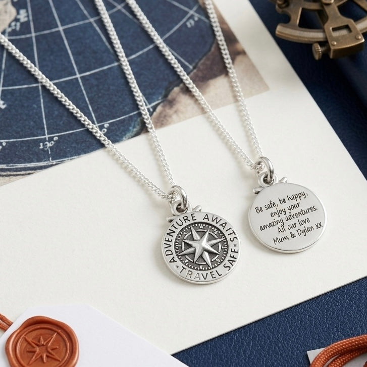 Two silver necklaces with engraved pendants on a decorative background