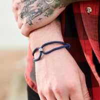 Unusual travel gift for men, vegan bracelet with silver Wanderlust charm.