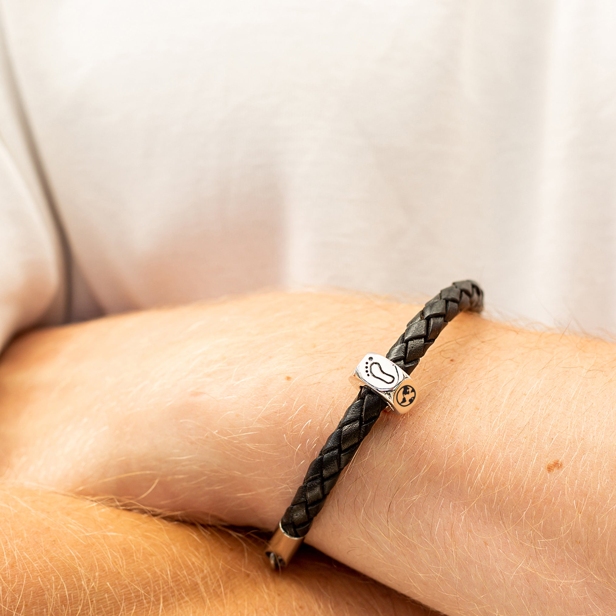 traveller charm bracelet with footprint and globe engraved